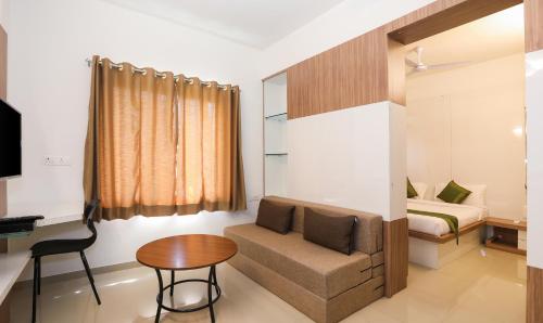 a room with a couch and a table and a bed at Treebo Sapphire Studio in Nashik