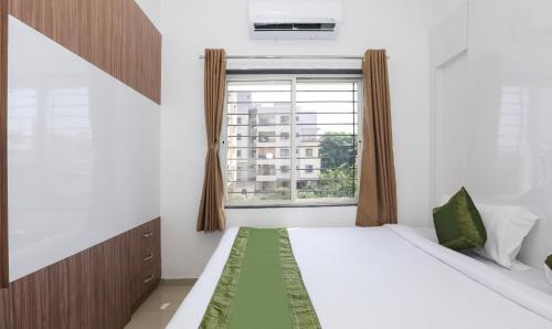 a bedroom with a bed and a window at Treebo Sapphire Studio in Nashik