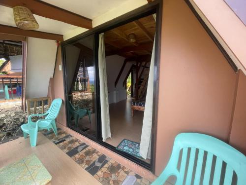 a screened in porch with two green chairs on it at Jai Hidden Paradise in Romblon