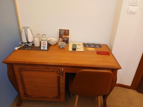 a wooden desk with a phone and a chair at Provence rooms in Banja Luka
