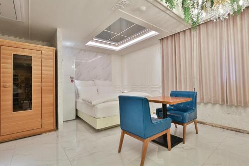 a room with a table and two chairs and a bed at Daegu February Hotel DongdaeguStation in Daegu