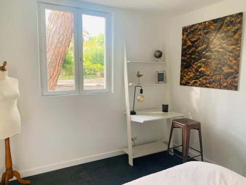 sypialnia z oknem, stołem i taboretem w obiekcie CANNES - PETIT JUAS, CHARMANTE VILLA AU CALME, TOUT CONFORT w Cannes