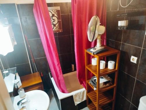 Łazienka wyposażona jest w różową zasłonę prysznicową i umywalkę. w obiekcie Apartamentos Málaga Centro Hernán Ruiz de 4 a 8 Personas w Maladze