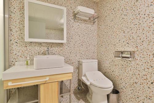 a bathroom with a toilet and a sink and a mirror at Daegu February Hotel DongdaeguStation in Daegu