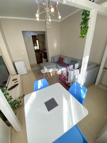 a living room with a white table and blue chairs at Aurora Al Sheikh Zayed in Sheikh Zayed