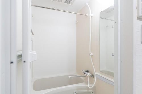 a white bathroom with a shower and a sink at KISETSU Omori I in Tokyo