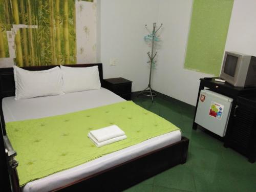 a bedroom with a bed with a tv on it at Sao Khue 2 Hotel in Buon Ma Thuot