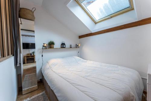 une chambre avec un grand lit avec une lucarne dans l'établissement Résidence Les Hauts De Preclaux - Appartement rénové avec belle vue sur les pistes MAE-8261, aux Orres