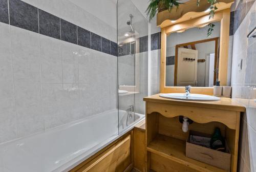 une salle de bain avec un lavabo, une baignoire et un miroir dans l'établissement Résidence Les Hauts De Preclaux - Appartement rénové avec belle vue sur les pistes MAE-8261, aux Orres