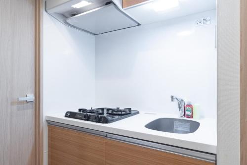 a kitchen with a sink and a stove at KISETSU Omori I in Tokyo
