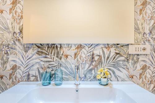 a bathroom sink with two vases and a mirror at Appartamenti Vista Mole, Centro a 15 min - Luxury Suites & fast WiFi in Turin