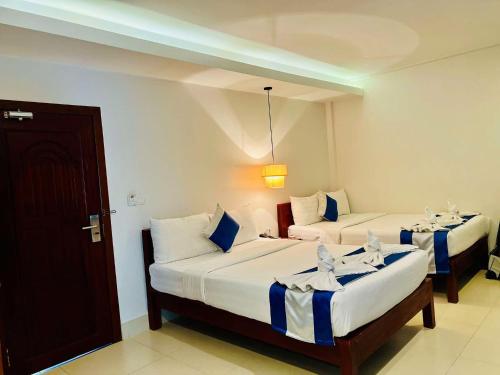 a hotel room with two beds and a door at Holy Angkor Hotel in Siem Reap
