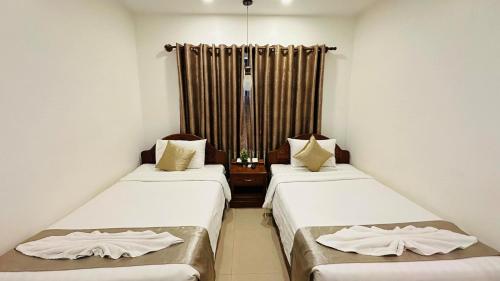 two beds in a room with white walls at Holy Angkor Hotel in Siem Reap