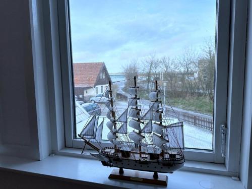 a model ship sitting in a window at Cozy Coastal Home in Egernsund in Egernsund