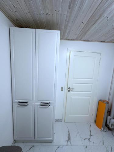 a room with two white cabinets and a door at Cozy Coastal Home in Egernsund in Egernsund