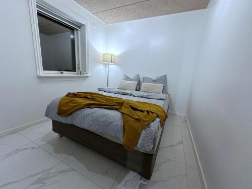 a bed in a white room with a window at Cozy Coastal Home in Egernsund in Egernsund