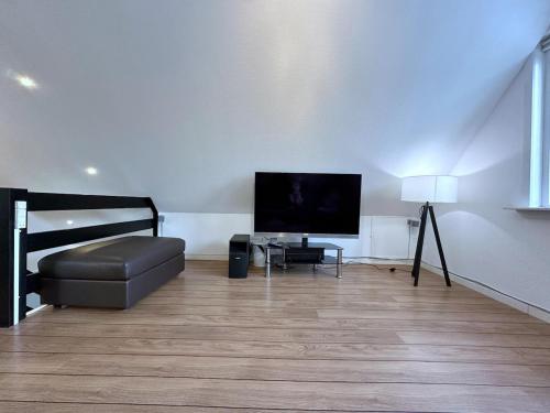 a living room with a television and a couch at Cozy Coastal Home in Egernsund in Egernsund