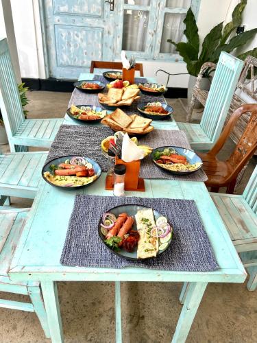 a picnic table with plates of food on it at Gypsea' Madiha in Matara