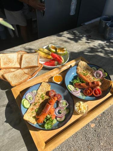 a wooden table with plates of food and bread at Gypsea' Madiha in Matara