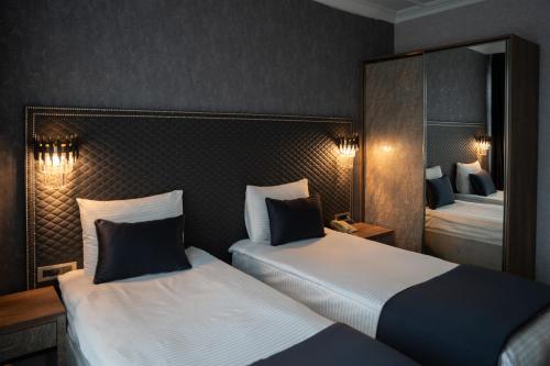 a hotel room with two beds and a mirror at saffari otel in Ankara