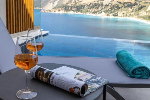 a table with a glass of wine and a magazine at Avithos - Lassu Retreat in Zóla
