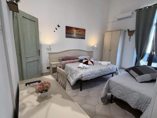 a bedroom with two beds and a table with flowers at Bed and Breakfast Station in Brindisi