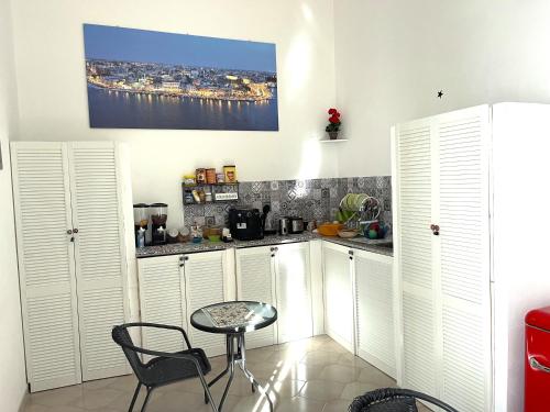 a kitchen with white cabinets and a table and chairs at Bed and Breakfast Station in Brindisi