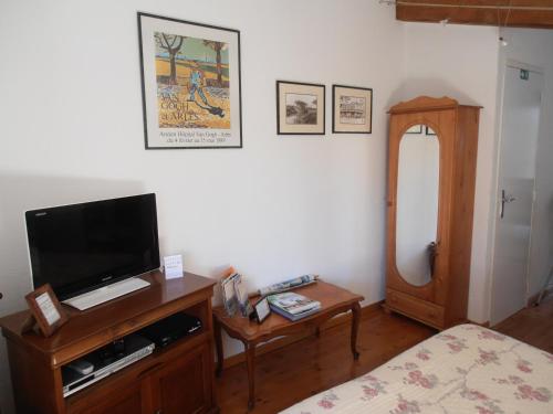 Cette chambre comprend un lit, une télévision et une table. dans l'établissement JAS en Provence, à Plan dʼAups