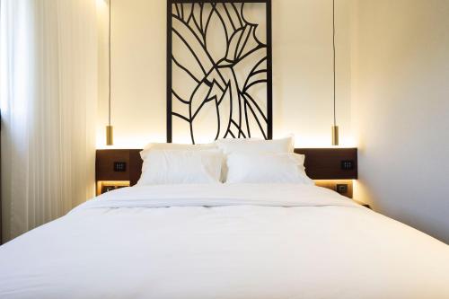 a bedroom with a large white bed with white pillows at מלון רמב"ן ירושלים - קבוצת מחניודה in Jerusalem
