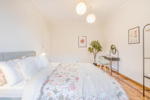 a white bedroom with a large bed and a desk at Appartamenti Vista Mole, Centro a 15 min - Luxury Suites & fast WiFi in Turin
