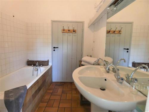 a bathroom with a tub and a sink and a bath tub at capbat in Commensacq