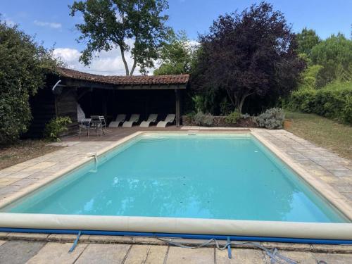 une grande piscine bleue devant une maison dans l'établissement capbat, à Commensacq