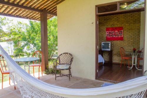 a hammock on the porch of a house at Pousada Império do Sol in Pipa