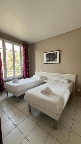 deux lits dans une chambre avec deux fenêtres dans l'établissement Villa Liberté Verdun IGR Paul Brousse, à Villejuif