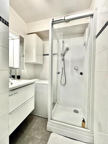 une salle de bain blanche avec une douche et un lavabo dans l'établissement Cannes 1 Bedroom Apartment - CC1, à Cannes