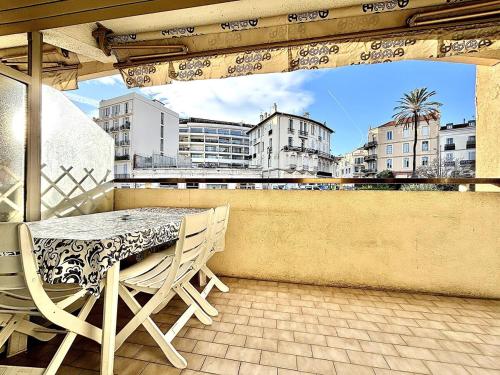 une table et des chaises sur un balcon avec vue sur une ville dans l'établissement Cannes 1 Bedroom Apartment - CC1, à Cannes