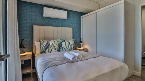 a bedroom with a bed with two towels on it at 105 Mossel Cove Unique & Trendy in Mossel Bay