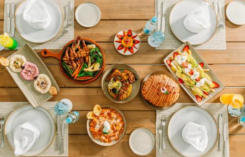 a wooden table with plates of food on it at Ramlah Resort Sealine Beach in Mesaieed