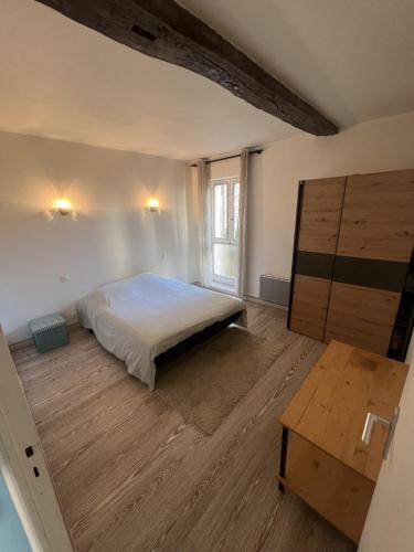 une chambre avec un lit et un parquet dans l'établissement Appartement Entier 38m2 T2 Hyper Centre de DAX, à Dax