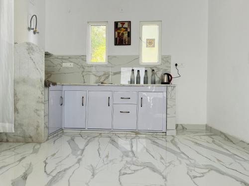 a bathroom with white marble floors and a sink at 2nd Homes in Dehradun