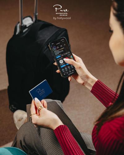 a woman holding a cell phone and a credit card at Pure Boutique Hotel in Baku
