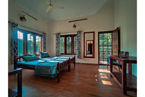 瓦亚纳德Spice Fields Cottage - 3 Bedroom - Wayanad的带窗户的房间里有一张床的卧室
