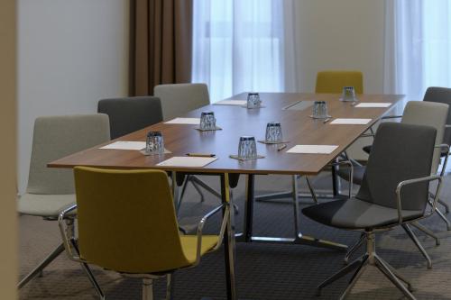 a conference room with a wooden table and chairs at IntercityHotel Herford in Herford