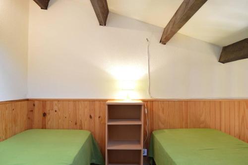 Cette chambre comprend 2 lits verts et une lampe. dans l'établissement SP220-033 Mais 3 pièces mezza 6 couchages SAINT PIERRE LA MER, à Saint Pierre La Mer