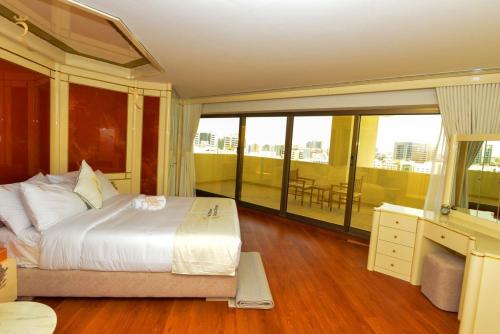 a bedroom with a large bed and a balcony at Timeless Elegance - Italian-Style Penthouse Retreat Near Corniche & WTC Mall in Abu Dhabi