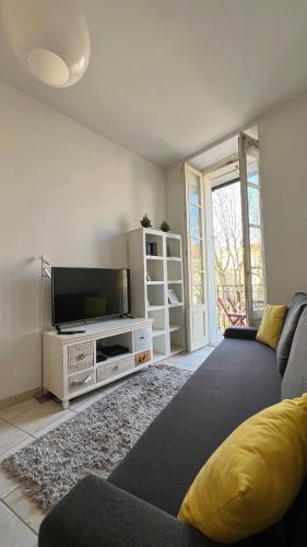 un salon avec un canapé et une télévision à écran plat dans l'établissement Place Grimaldi, close to beach and restaurants, with balcony, à Nice