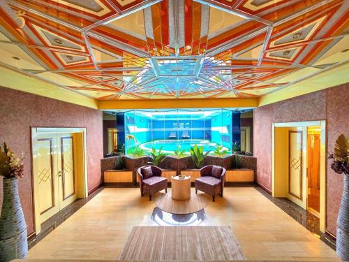 a lobby with a table and chairs and an aquarium at Timeless Elegance - Italian-Style Penthouse Retreat Near Corniche & WTC Mall in Abu Dhabi