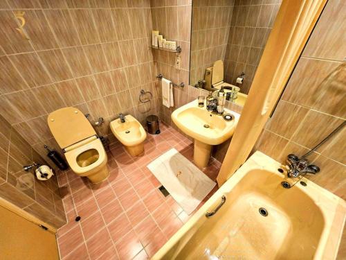 a bathroom with a toilet and a bidet and a sink at Timeless Elegance - Italian-Style Penthouse Retreat Near Corniche & WTC Mall in Abu Dhabi