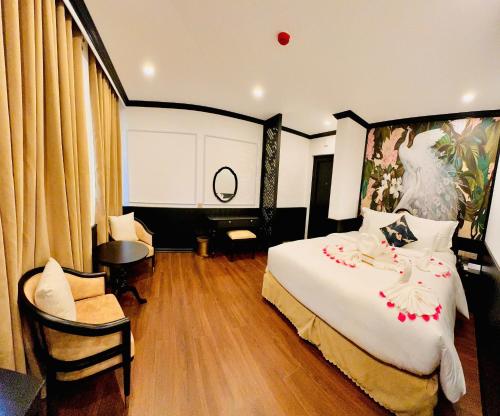 a bedroom with a large bed and a chair at The ORCHID PREMIUM Hotel in Hue