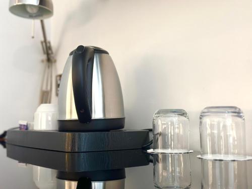 a coffee maker and two glasses on a table at Club House Hotel in Rimini